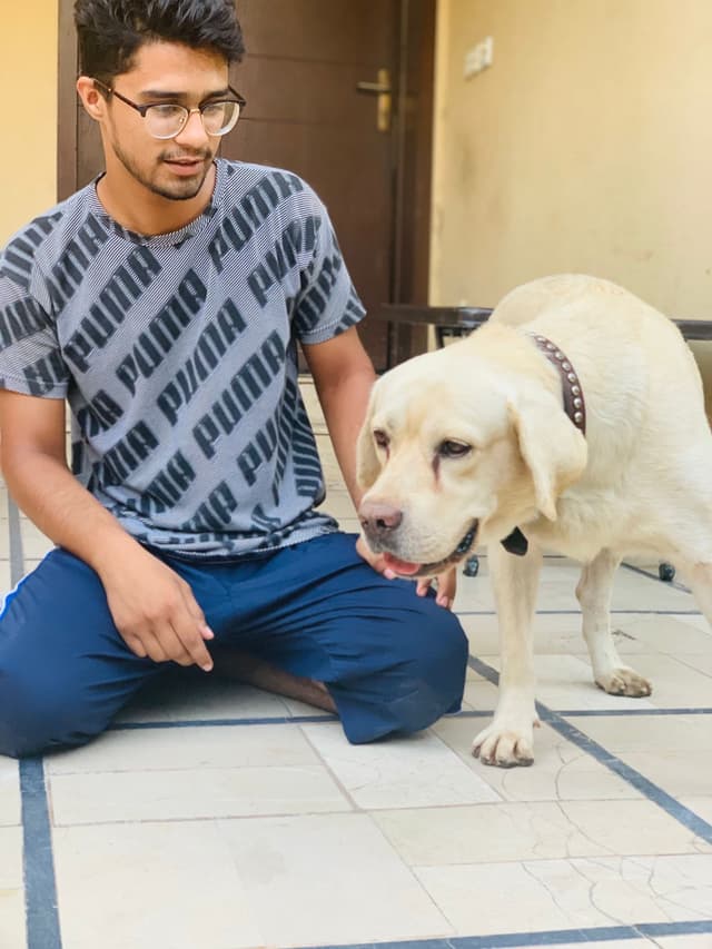 Saaim relaxing outdoors with a dog